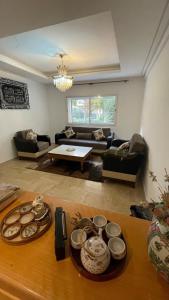 a living room with a table with dishes on it at Appartement moderne équipé, situé au centre de Oujda in Oujda