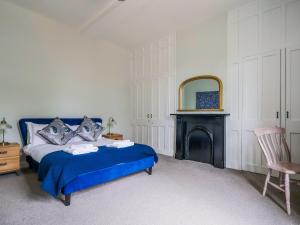 a bedroom with a blue bed and a mirror at Salt House - Uk43012 in Berkeley