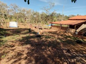 ein unbefestigter Hof mit einem Zelt und einem Gebäude in der Unterkunft Camping dos oliveira in Jaboticatubas