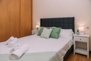 a bedroom with a large bed with towels on it at Calma y relax cerca del mar by CABANA Rentals in Ribeira