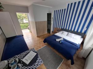 a bedroom with a blue and white striped wall at Willa Morski Klimat in Łeba