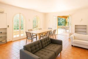 a living room with a couch and a table and chairs at Villa Ganesha Piscine Plage in Port Grimaud