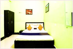a bedroom with a bed with yellow and blue pillows at VARANASI HOTEL H R GUEST HOUSE Near Kasi Visawanath Temple & Ganga Ghat - #Free Wi-Fi #Room service #Parking #Fully Air conditioning #Premium Room In Varanasi in Varanasi +14 photos