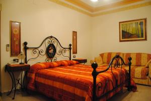 een slaapkamer met een bed en een bank bij Hotel Ristorante la Siesta in Pietrapaola +29 foto's