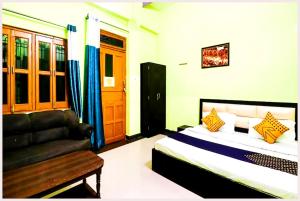 a bedroom with a bed and a couch at VARANASI HOTEL H R GUEST HOUSE Near Kasi Visawanath Temple & Ganga Ghat - #Free Wi-Fi #Room service #Parking #Fully Air conditioning #Premium Room In Varanasi in Varanasi