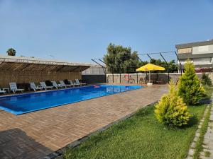 a swimming pool with chairs and a yellow umbrella at Taş Konak - DEMRE in Demre