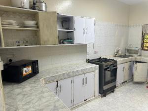 a kitchen with white cabinets and a stove in it at Sweet Mum in Malindi