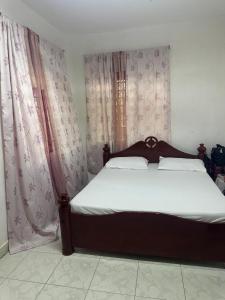 a bedroom with a large bed with pink curtains at Sweet Mum in Malindi