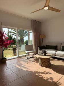 a living room with a couch and a table at Mirador las Cumbres Conil - Piscina Jardín XL in Conil de la Frontera