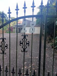 a gate with the number on it in front of a building at Ground Floor apartment-2 x single beds, TV,kitchen, own bathroom, patio in Pinetown