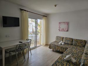a living room with a couch and a table at Venecia Apartments in Port d'Alcudia