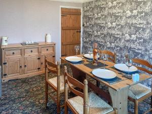 a dining room with a wooden table and chairs at Bondcroft Farm Cottage in Embsay