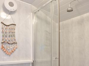 a shower stall with a glass door with a curtain at Awd Tuts in Whitby