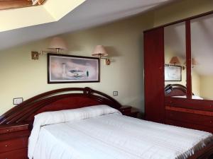 a bedroom with a large bed and a large mirror at Hostal Acantilado in Villadaíde