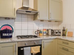 Una cocina con gabinetes blancos y un horno de estufa. en Tankerton Heights, en Whitstable