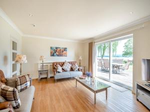 a living room with a couch and a table at Duck Bay Cottage 1 - Uk43934 in Balloch