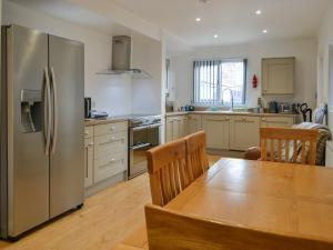 a kitchen with a table and a stainless steel refrigerator at Trinity Avenue Cottage in Bridlington +21 photos