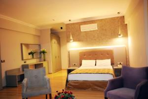 a hotel room with a bed and two chairs at Pasa Garden Beach in Marmaris