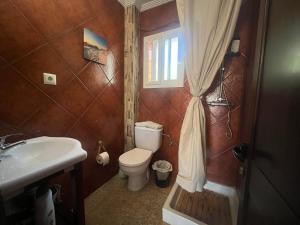 a bathroom with a toilet and a sink and a window at PINO BEACH in Punta Umbría +12 photos