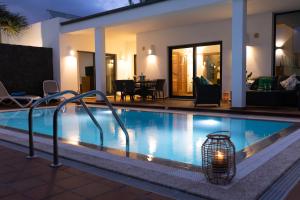 a swimming pool with a light in front of a house at Villas Mamma Mia pool heat Private & Jacuzzi in Playa Blanca