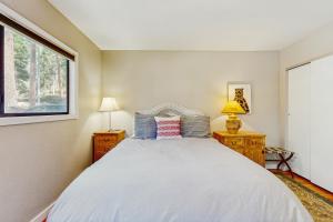 a bedroom with a white bed with two night stands and a window at Casual and Cute Cabin Near the Lake in Tahoe Vista