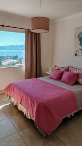 Un dormitorio con una cama grande con una ventana grande. en De cara al lago Bariloche U4, en San Carlos de Bariloche