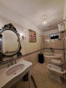 a bathroom with a sink and a mirror and a toilet at Joy19 B&B in Albissola Marina