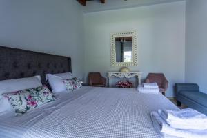 une chambre avec un lit et deux chaises et un miroir dans l'établissement Villa Olive & Stone Loutraki, à Loutraki