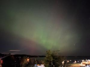 an aurora in the sky over a city at night at Eco-friendly studio - ocean views, close to beach in Lincolnville