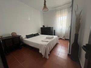 a bedroom with a white bed and a window at PINO BEACH in Punta Umbría