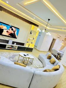 a living room with a white couch and a tv at SolarisApartment in Abuja