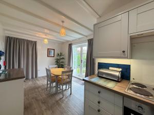 une cuisine et une salle à manger avec une table et des chaises dans l'établissement Pass the Keys Gorgeous 3 BR Cottage with Outstanding Sea Views, à Isle of Whithorn