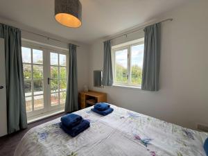 une chambre avec un lit avec deux serviettes bleues dessus dans l'établissement Pass the Keys Gorgeous 3 BR Cottage with Outstanding Sea Views, à Isle of Whithorn