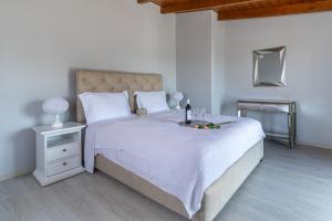 une chambre avec un lit blanc avec un plateau de fruits dessus dans l'établissement Villa Olive & Stone Loutraki, à Loutraki