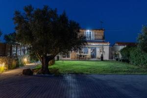 une grande maison avec un arbre devant dans l'établissement Villa Olive & Stone Loutraki, à Loutraki 56 autres photos