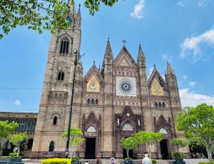 a church with a tower and a clock on it at Espacio Libertad Colonia Americana in Guadalajara