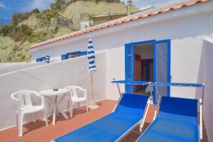 a balcony with blue chairs and a table on a house at Hotel Regina del Mare in Ischia