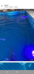 a pool of blue water with a person in it at Sergio in Mongaguá
