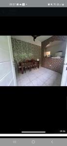 a dining room with a table and a brick wall at Sergio in Mongaguá