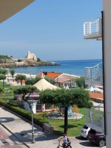 a person riding a bike down a sidewalk near the ocean at Casa Blu with Sea View - Borgo Stays in Sperlonga