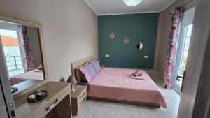 a bedroom with a pink bed and a mirror at Vasilikis Place in Elafonisos
