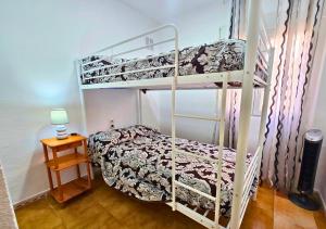 a bedroom with two bunk beds and a table at Bungalow Oaxaca Playa de La Mata in Torrevieja