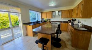a kitchen with a island in the middle of it at Luxury Seaview Escape - Mumbles in Oystermouth