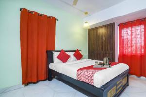 a bedroom with a bed with red curtains at Hotel O RR in Hyderabad +38 photos