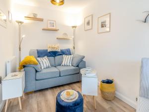 a living room with a blue couch and two tables at Blue Skies in Carew