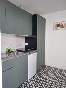 a kitchen with white cabinets and a black and white tile floor at Oporto Seaside Village - Casa Quinta in Matosinhos