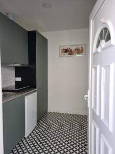 a kitchen with a black and white tiled floor at Oporto Seaside Village - Casa Quinta in Matosinhos