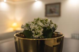 a metal vase with flowers in it on a table at Grande maison des Compagnons in Val de Reuil