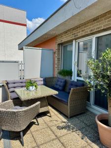 a patio with a couch and a table and chairs at Panorama Apartment Šamorín in Šamorín