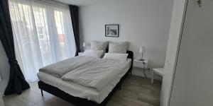 a bedroom with a bed with white sheets and a window at LandRäume barrierefrei in Lunden